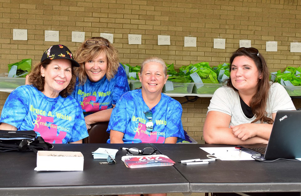 Nancy and Jill Waite, from left, along with other volunteers work the registration table during the 2019 Bruce A. Waite Miles for Meso 5K